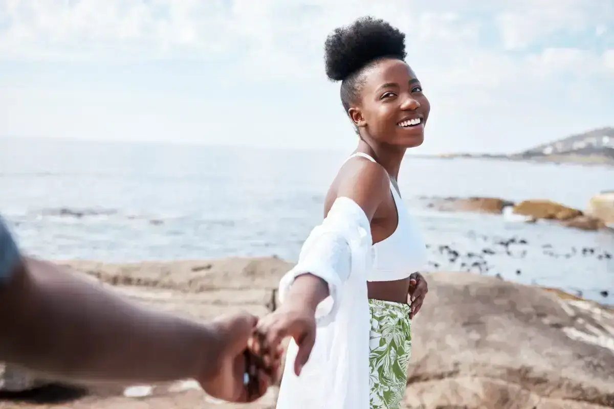 Beach, travel and holiday, black couple holding hands while on a walking at the ocean. Nature, love