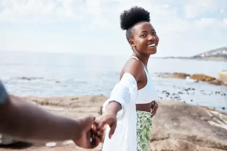 Beach, travel and holiday, black couple holding hands while on a walking at the ocean. Nature, love