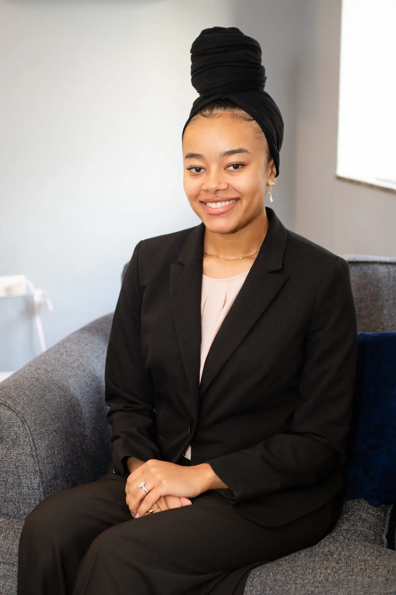 A professional headshot of a Kalila our intern therapist, a confident and approachable individual with a warm expression, dressed in business casual attire against a neutral background.